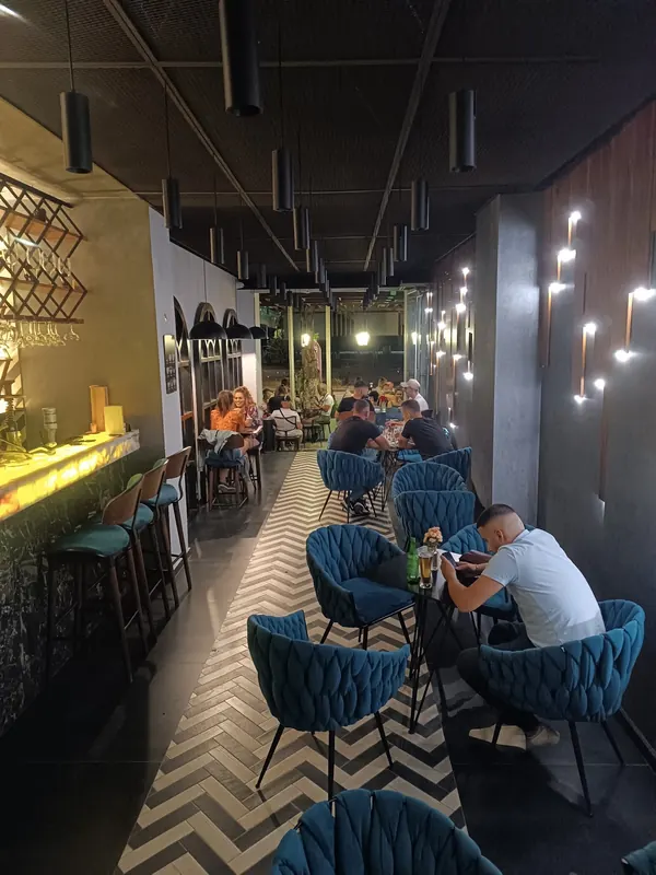 Teal armchairs along the zigzag floor of the lounge