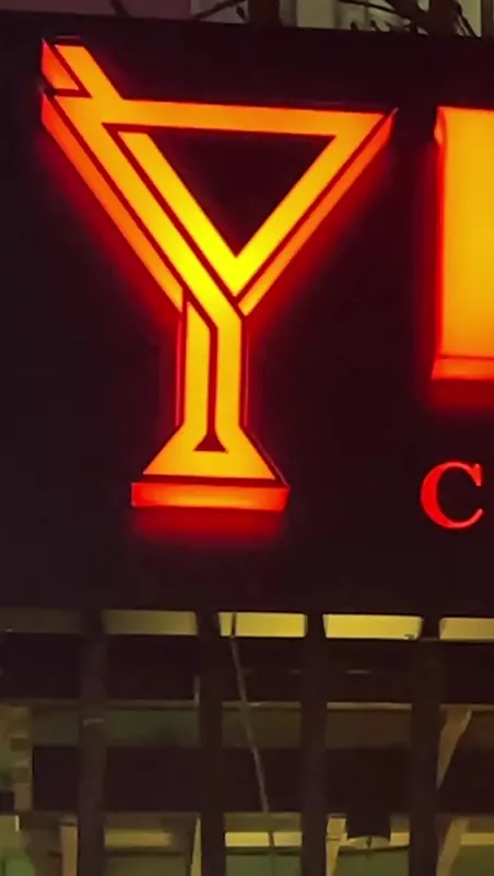 The cocktail glass of Bazar's neon sign, glowing at night