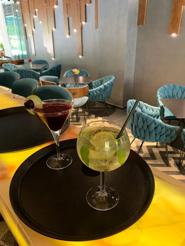 Two cocktails on a tray on the glowing bar